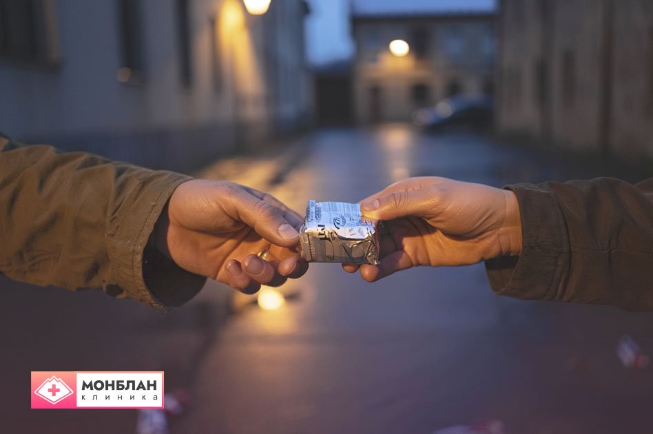 Рука передает предмет в руку другого человека